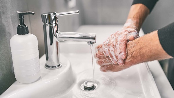Man Washing Hands in Sink